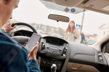 A man is driving his car while using his phone in Las Vegas, NV