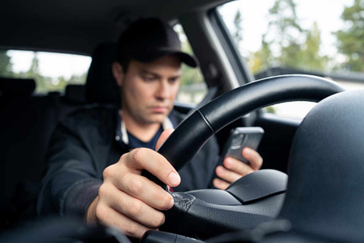 A man is using his mobile phone and is driving his car in Las Vegas, NV